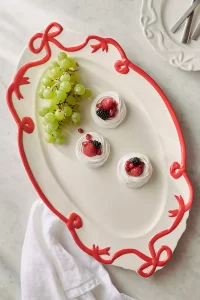 An oval Benedita Bow Ceramic Stoneware Platter with a delicate bow detail. A top rated Anthropologie gift for serving and entertaining.
